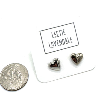Heart-shaped earrings on a card with 'Leetie Lovendale' branding, next to a quarter for scale.