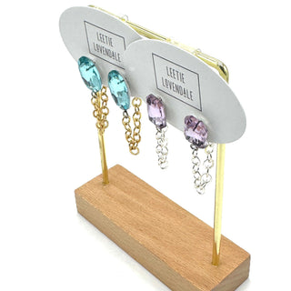 Earring display stand with gold and silver earrings on a white background