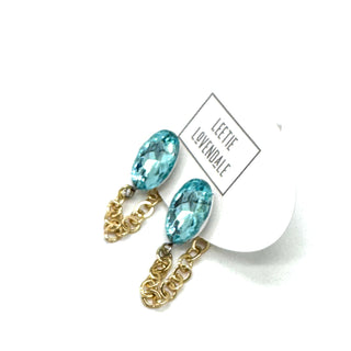 Gold chain earrings with blue gemstones on a white background
