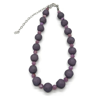 Adjustable necklace featuring dark gray and lilac lucite beads laid on a white background.