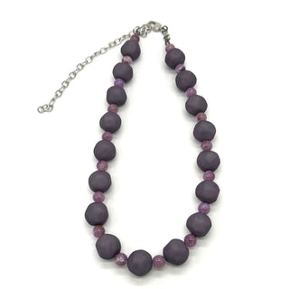 Adjustable necklace featuring dark gray and lilac lucite beads laid on a white background.