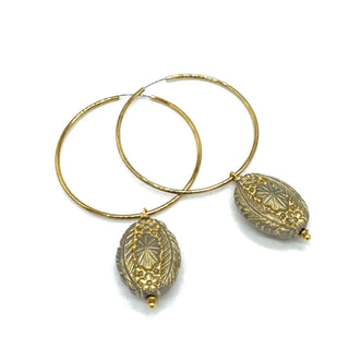 Hoop earrings with carved gray bead dangles with gold leaf.