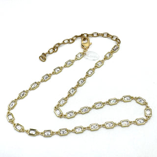 Gold chain necklace with clear stones on a white background