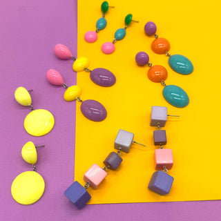 Colorful necklace and earrings on a purple and yellow background