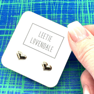 Silver heart stud earrings on a white branded card with a blue and green background.