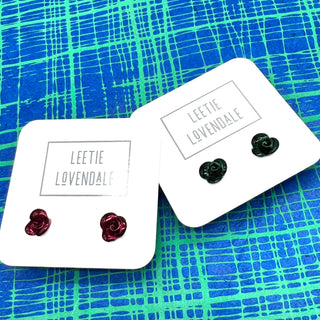 Two pairs of earrings on 'Leetie Lovendale' branded cards against a blue and green patterned background.