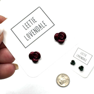 Rose-shaped earrings on a 'Leetie Lovendale' branded card with a coin for size comparison.