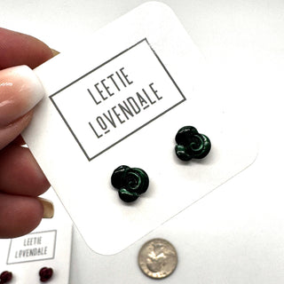 Green flower-shaped earrings on a card with 'Leetie Lovendale' branding, held by a hand.