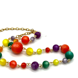 Colorful beaded necklace with gold chain on a white background