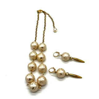 Dangle earrings with floral cream colored beads and golden accents with matching necklace on a white background.