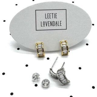 Silver and gold crystal hoop earrings on branded earring cards.