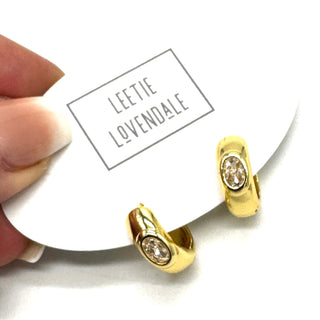 Gold and crystal hoop earrings on an earring card.
