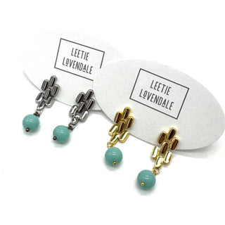 Silver and gold drop earrings with turquoise glass beads.