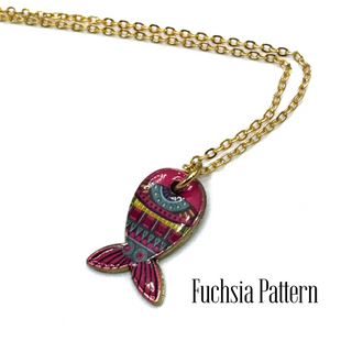 A gold chain necklace with a fish-shaped pendant featuring a vibrant fuchsia and pink pattern, shown on a white background with the text 'Fuchsia Pattern' in the lower right.