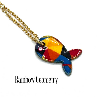 A gold chain necklace with a colorful fish-shaped pendant featuring a geometric rainbow pattern of red, orange, yellow, blue, and black, displayed on a white background with the text 'Rainbow Geometry'.