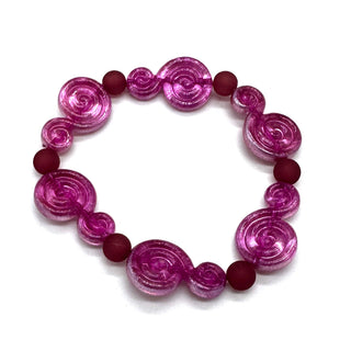 A beaded stretch bracelet featuring translucent pink spiral beads and matte dark red round beads, displayed on a clean white background.