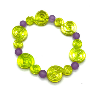 A beaded stretch bracelet featuring translucent lime green spiral-shaped beads and matte purple round beads, displayed on a clean white background.