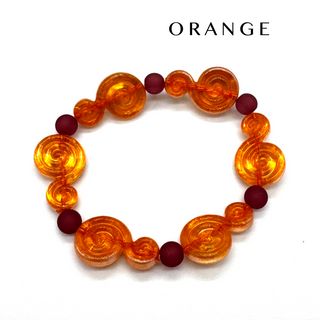 An orange beaded bracelet with translucent spiral-shaped beads and dark red round accent beads, displayed on a white background with the word 'ORANGE' printed above.