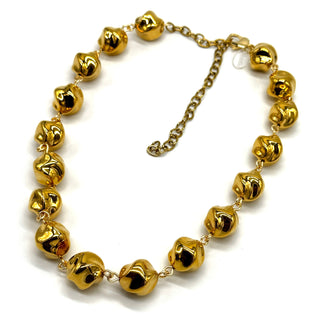 A gold-toned beaded necklace featuring textured, polished, twisted round beads connected by delicate chain links, with an adjustable clasp, shown on a plain white background.